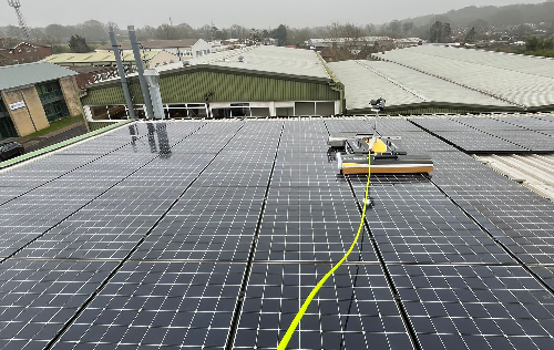 Wagner Renewables' Solar Pnalet Cleaning robot called Basic. The robot is cleaning solar panels on an industrial roof.